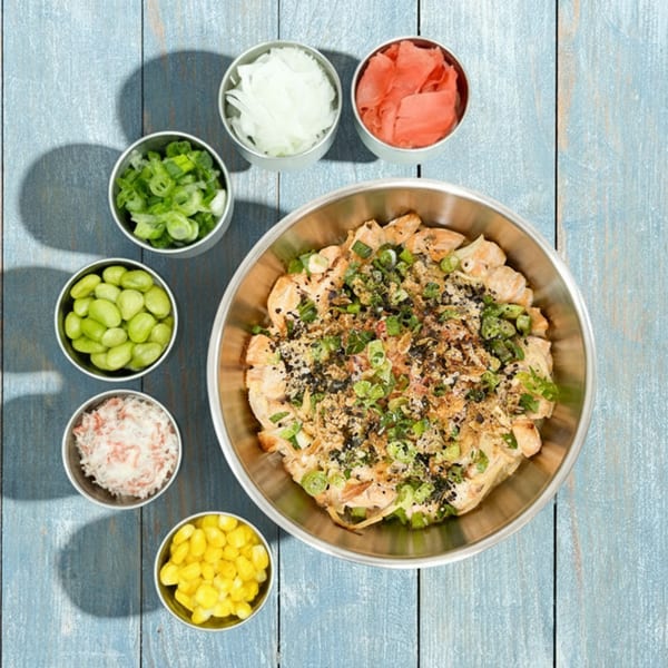 Sunfish Poke Bar's poke bowl with chicken, green onions, sesame seeds, and various toppings.